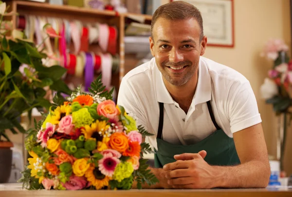 Smiling florist next to a coloful bouquet