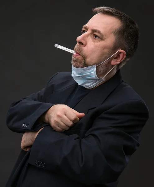 Man in medical mask with a thermometer