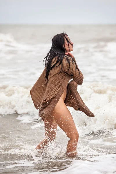 Seminude woman in the cold sea waves