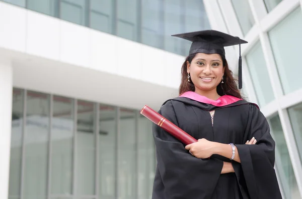 Young indian female graduate with campus background