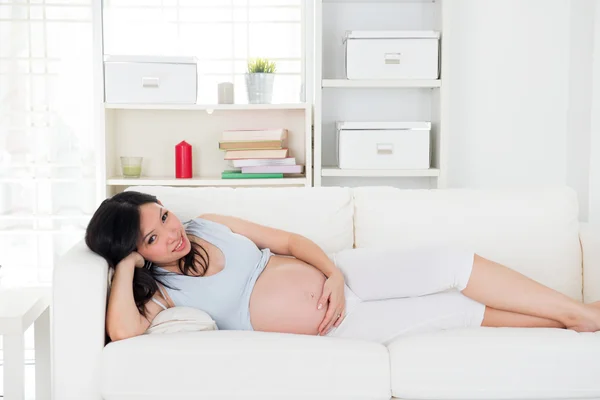 Asian pregnant mother sitting on couch