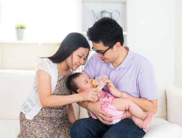 Asian parents feeding baby boy at home