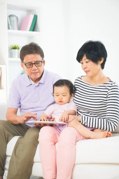 Asian grandparents teaching granddaughter internet