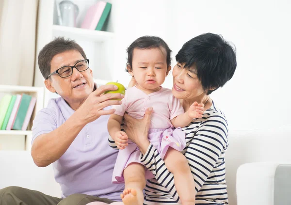 Asian grandparents comforting their grand daugther