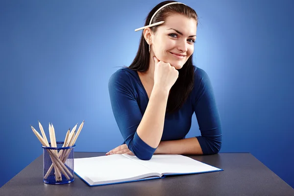 Smiling young student sitting at her desk