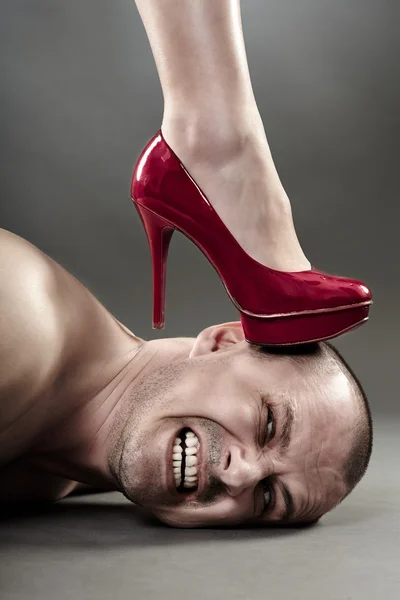 Woman\'s foot crushing man\'s head