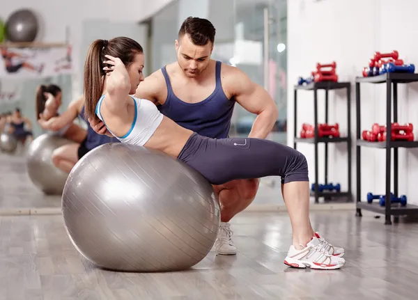 Personal trainer helping woman at gym