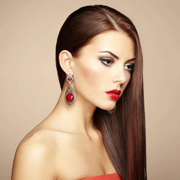 Portrait of beautiful brunette woman with earring. Perfect makeu