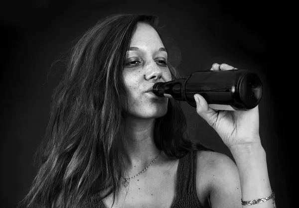 Drunk woman drinking beer over black BW