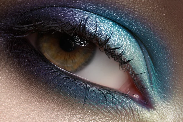Elegance close-up of beautiful female eye with marine colors eyeshadow. Macro shot of beautiful woman\'s face part with makeup. Cosmetics, beauty and make-up
