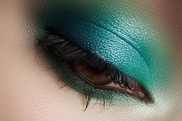 Elegance close-up of female eye with mint color eyeshadow. Macro shot of beautiful woman\'s face part. Wellness, cosmetics and make-up