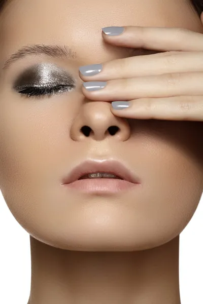 Spa, beauty, skincare, wellness & health. Glamour close-up portrait of beautiful woman model face with purity healthy skin & silver make-up and grey manicure. Cold winter christmas makeup