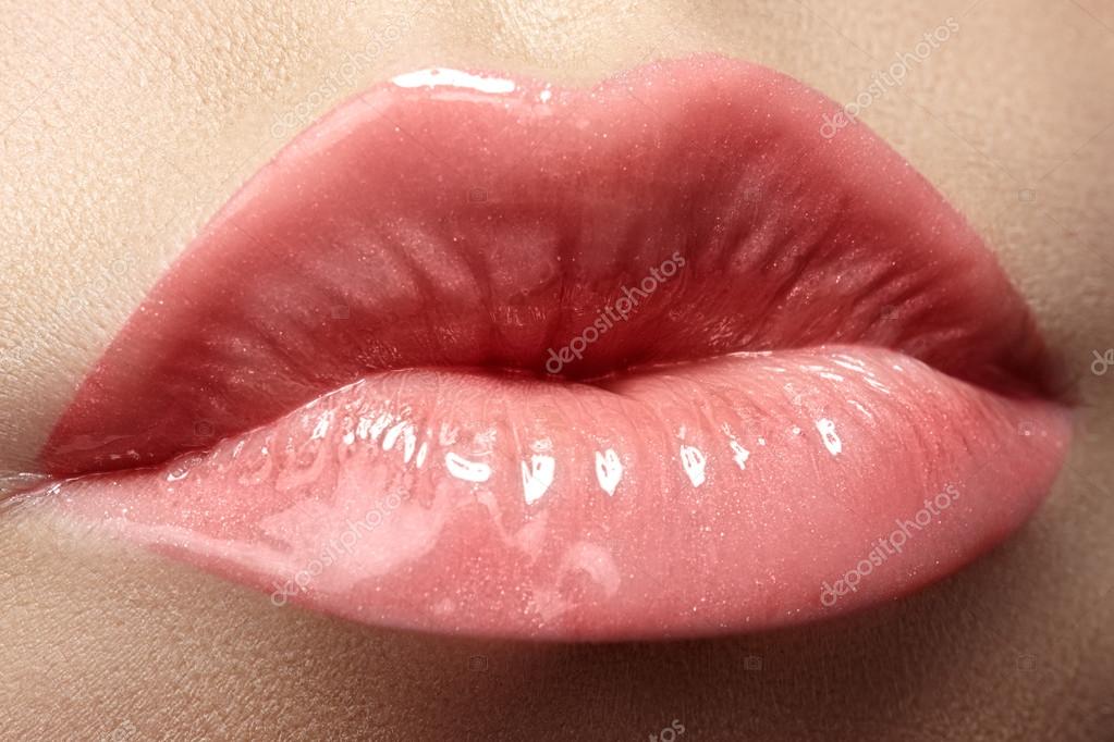 化粧品とメイクアップ。ピンクの口紅と光沢を持つ女性の美しい唇のクローズ アップを撮影します。セクシーな濡れた唇メイク