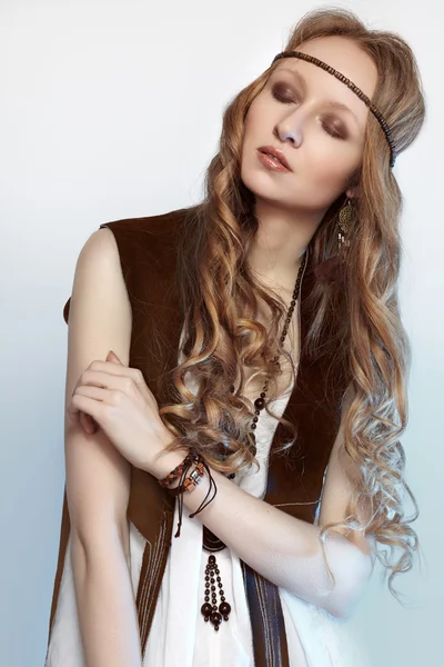 Bohemian woman in spring and summer clothes with beautiful accessories, natural make-up and shiny hairstyle. Fashion hippie style. Long curly hair