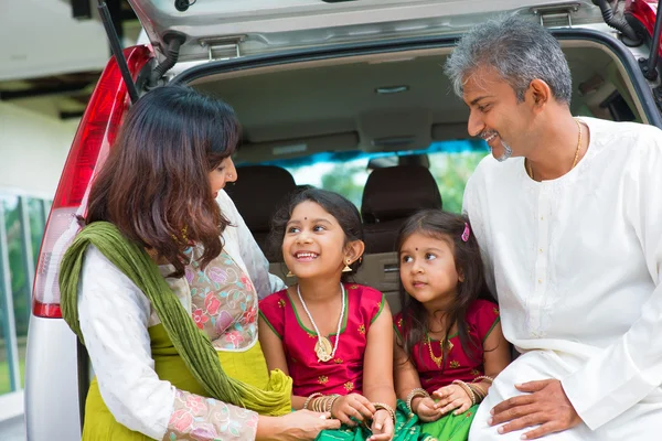 Indian family in car infront new house.