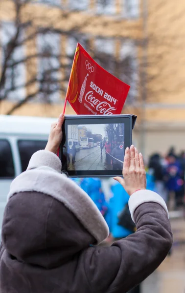 January 11, 2014, Saratov, Russia. Olympic Torch Relay Sochi 2014. Woman shoots video with a tablet