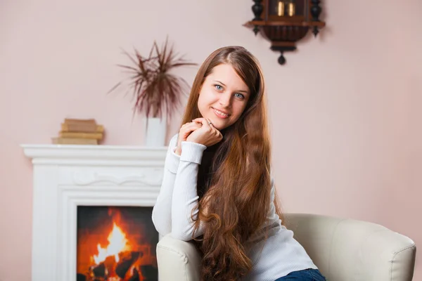 Girl sitting by the fireplace