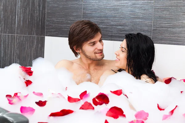 Young happy couple lying in jacuzzi