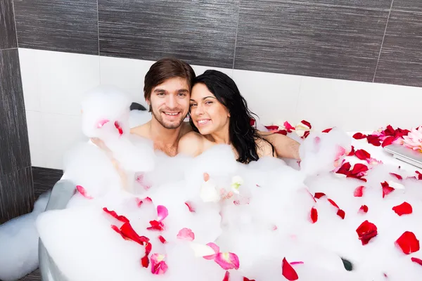 Young happy couple lying in jacuzzi