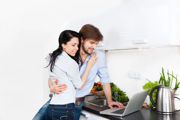 Couple using laptop at their kitchen