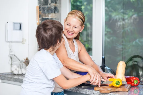 Grandmother and little boy cooking