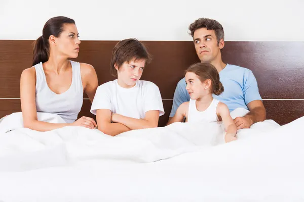 Unhappy family lying in  bed
