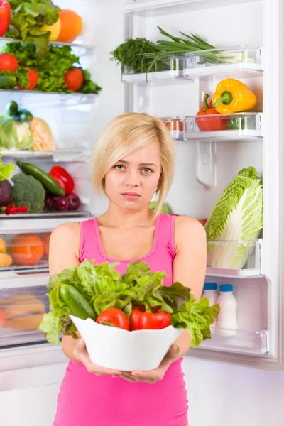 Unhappy woman holds salad