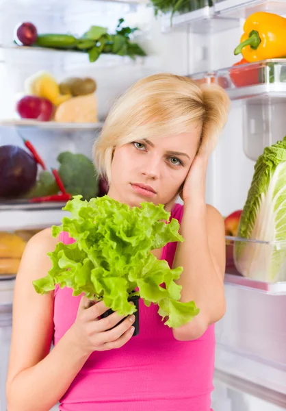 Unhappy woman holds salad