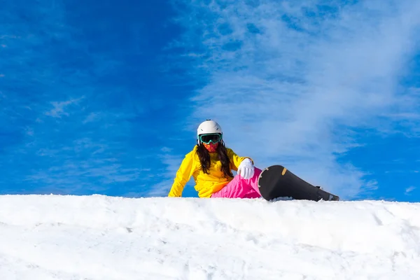 Snowboarder sitting on mountain slope