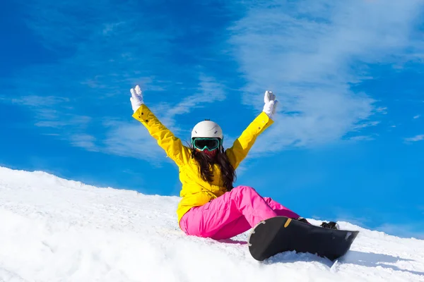 Snowboarder sitting on mountain slope