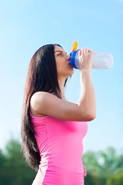 Woman drinking water on stadium
