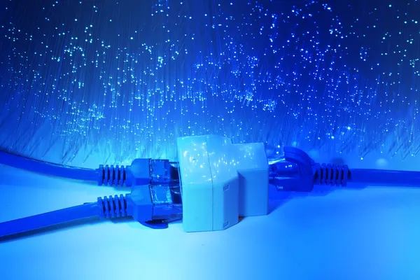 Network cables and hub closeup with fiber optical background