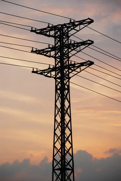Electricity pylon with long lines in the sunset.