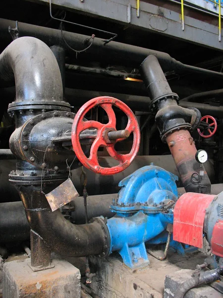 Red valve and electric water pumps at power plant