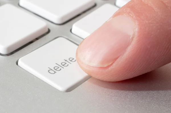 Finger pressing a DELETE key