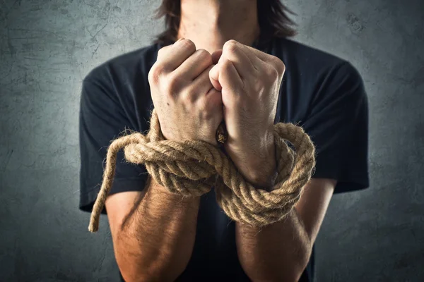 Male hands tied with a rope