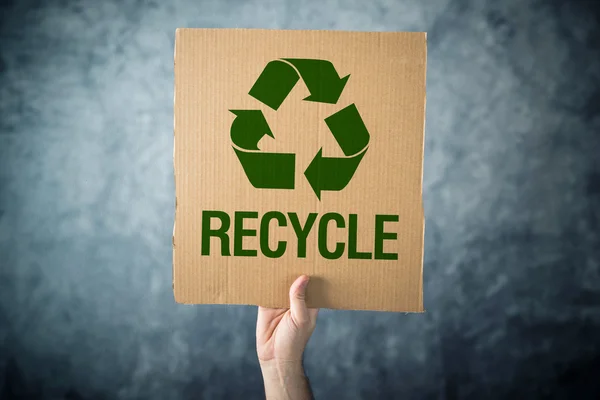 RECYCLE. Man holding cardboard with Recycle symbol printed