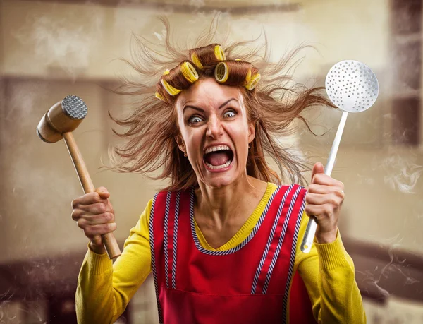 Crazy housewife with kitchen tools