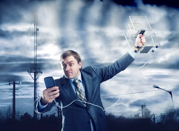 Businessman trying to find signal in storm