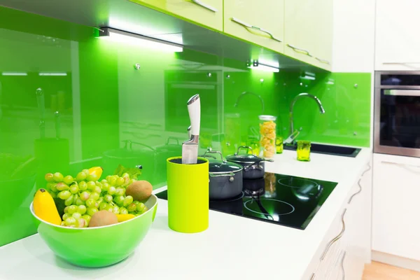 Green kitchen interior shot with fruits