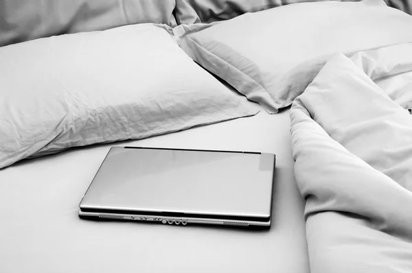 Laptop on unmade bed