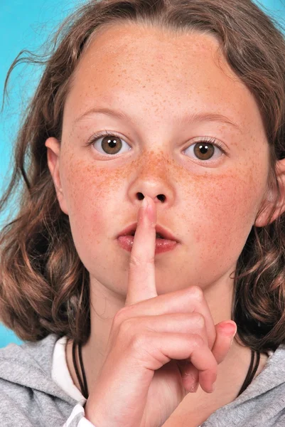 Young blond woman finger over her mouth