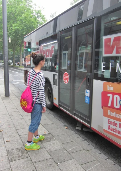 Teenage girl getting on bus.