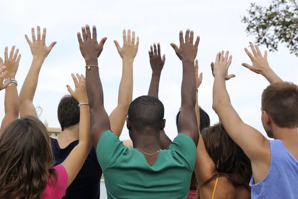 Diverse group raising hands