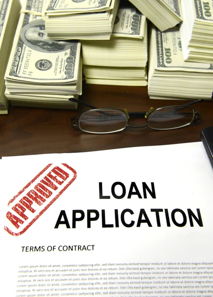 Approved loan application and dollar bills