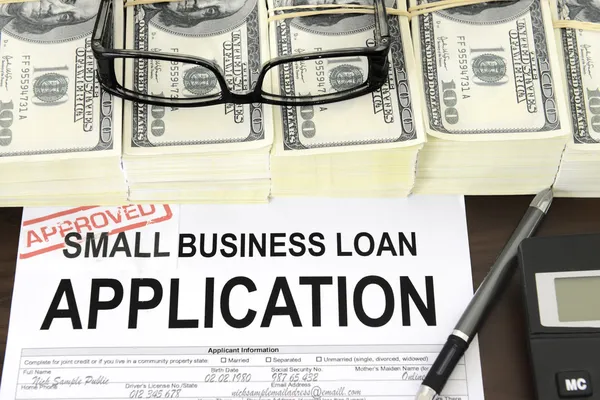 Approved small business loan application form and money