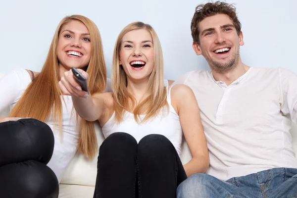 Group of young people watching tv at home