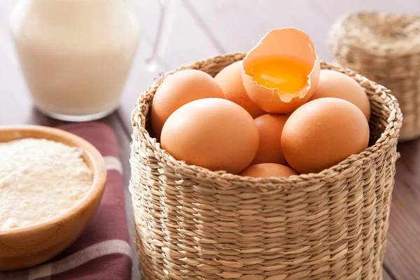 Eggs, milk and flour on a wooden table