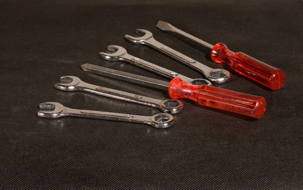 Wrenches and screwdrivers set on black textile