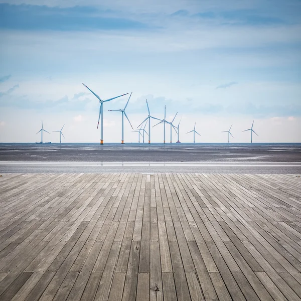 Wind farm in mud flat with wooden floor